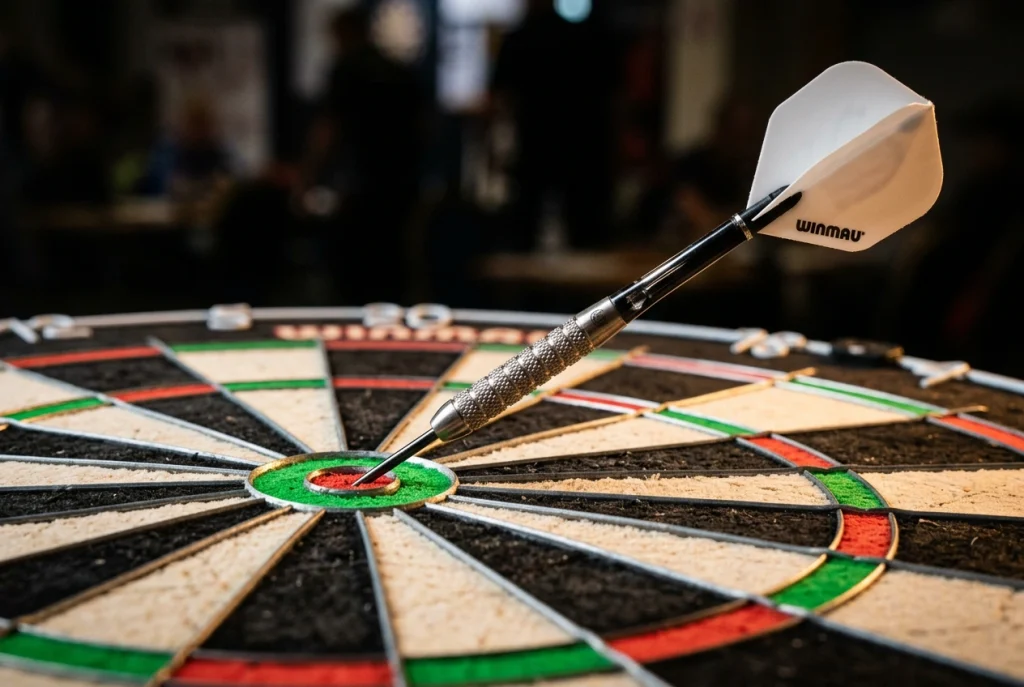 Einzelner Steeldart mittig im Bullseye eines beleuchteten PDC-Tournament-Dartboards